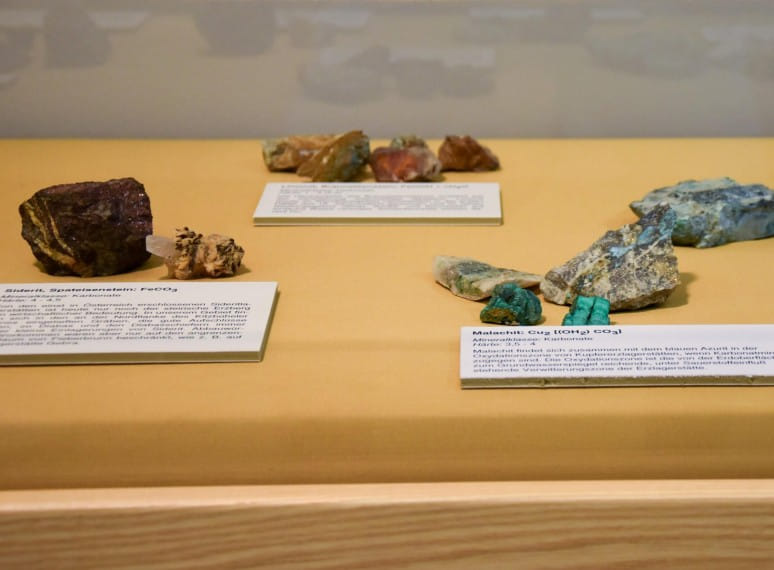 Ausstellungsvitrine mit verschiedenen Mineralien und dazugehörigen Beschreibungen auf Kärtchen. 