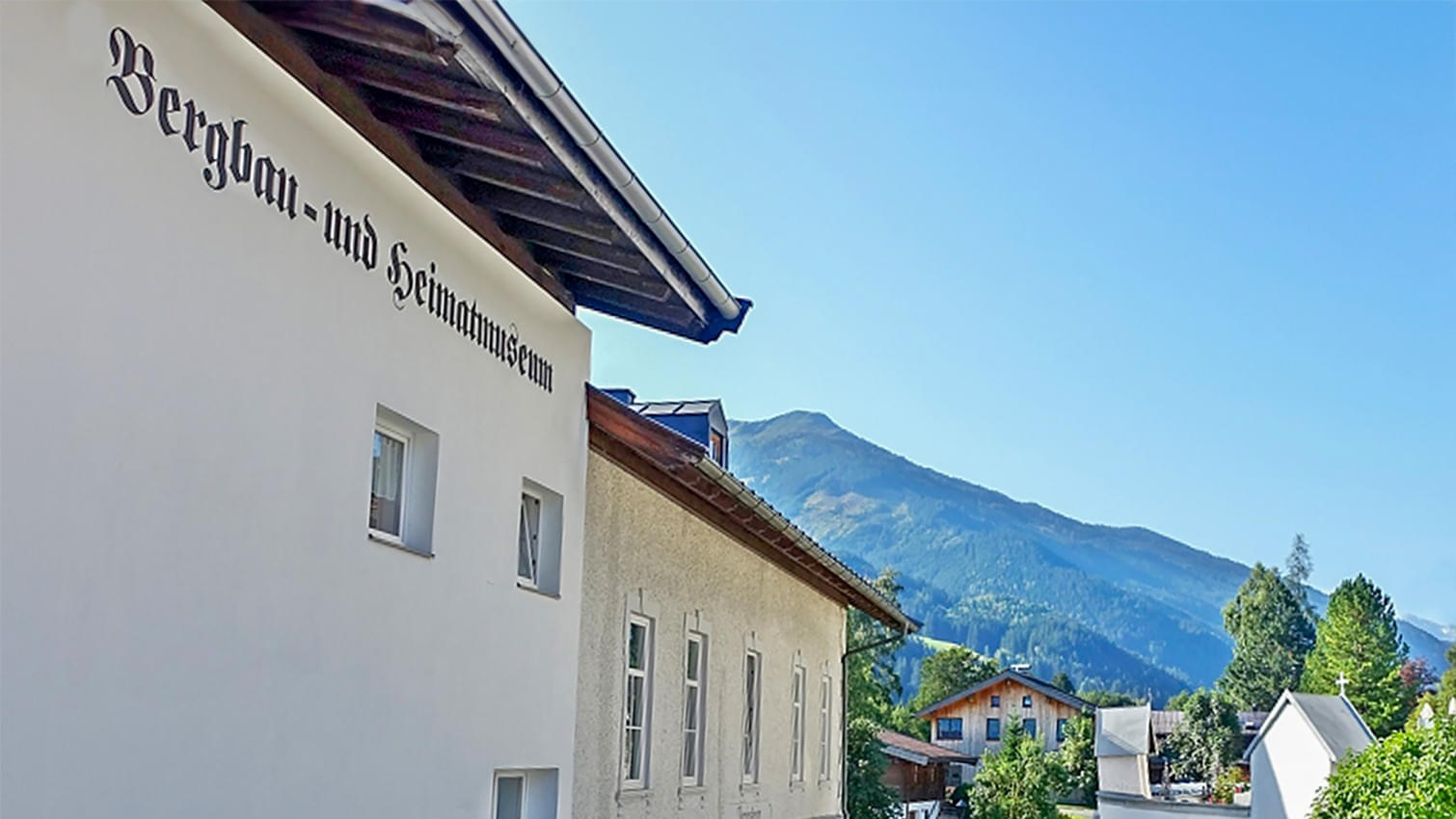 Außenansicht des Bergbau- und Heimatmuseums in Jochberg, eingebettet in eine malerische Berglandschaft.